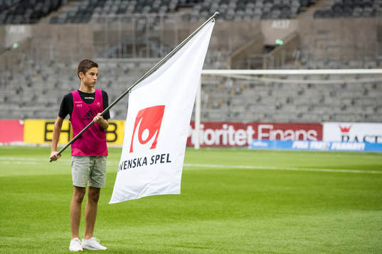 En flagga med Svenska Spels logo innan fotbollsmatchen i