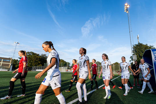 Spelarna i båda lagen gör entré till fotbollsmatchen i