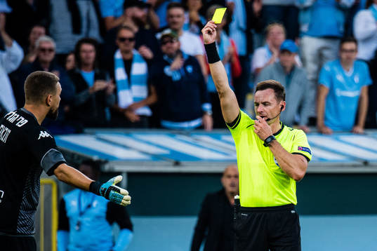 Referee Pawel Raczkowski gives goalkeeper Emilijus Zubas of