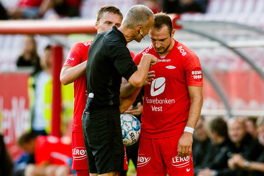 Tommy Skjerven, referee, talks to Veton Berisha of Brann