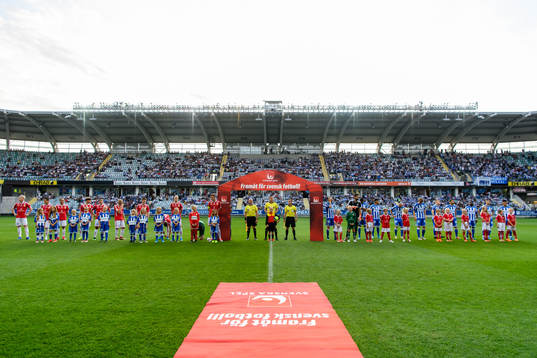 Spelarna står vid lineup innan fotbollsmatchen i