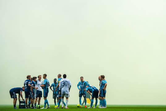 Djurgårdens spelare samlas framför rök av pyroteknik