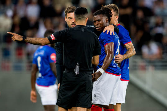 Sam Adekugbe of Vålerenga talks to Rohit Saggi, referee