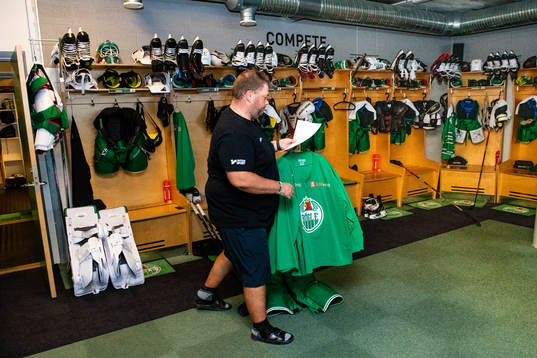 Materialförvaltare Frederik Andersen hänger ut tröjor i