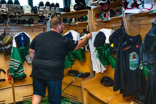 Materialförvaltare Frederik Andersen hänger ut tröjor i