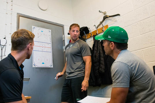 Rögles tränare Cam Abbott ritar på en whiteboard i