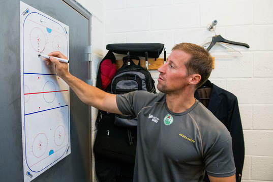 Rögles tränare Cam Abbott ritar på en whiteboard i