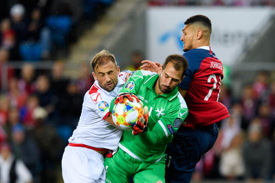 Andrei Agius and goalkeeper Henry Bonello of Malta and