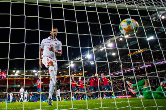 Steve Borg of Malta looks dejected while Joshua King of
