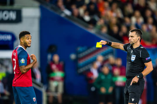 Joshua King of Norway gets a yellow card by Dumitru
