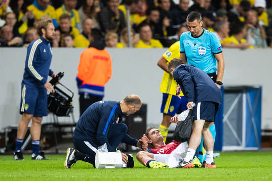 Markus Henriksen of Norway gets medical attention due to