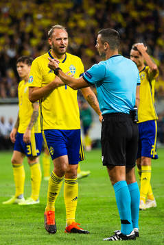 Andreas Granqvist of Sweden in discussion with referee