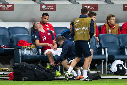 Markus Henriksen of Norway gets medical attention due to