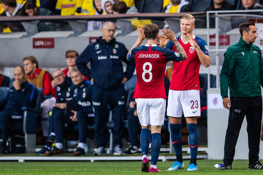 Stefan Johansen changes with Erling Braut Haaland of Norway