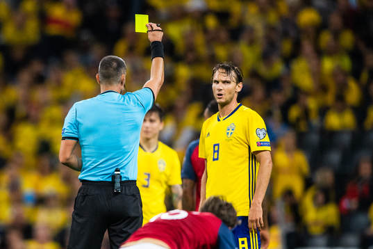 Referee Slavko Vincic awards Albin Ekdal of Sweden a yellow