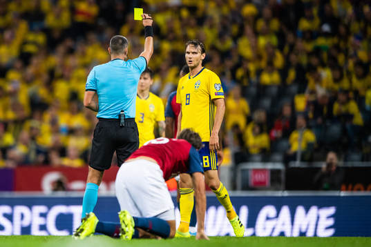 Referee Slavko Vincic awards Albin Ekdal of Sweden a yellow