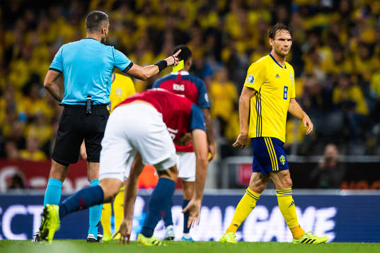 Referee Slavko Vincic awards a yellow card to Albin Ekdal