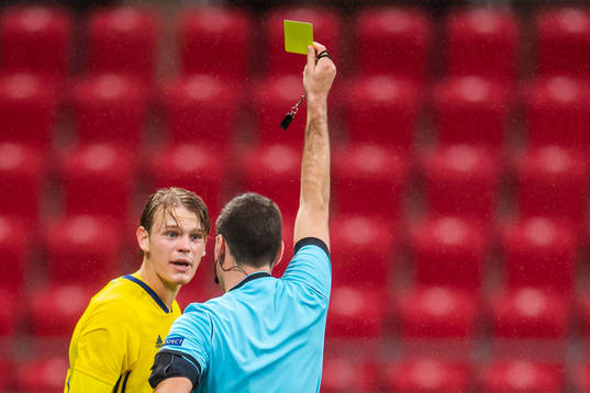 Hugo Andersson of Sweden is shown a yellow card