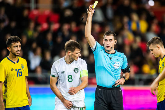 Jayson Molumby of Ireland is shown a warning