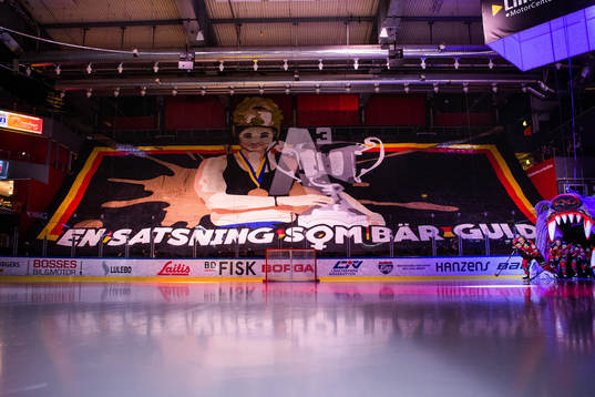 Luleås spelare åker in på isen med tifo på läktaren