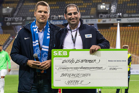 Norrbys klubbchef David Kryssman överlämnar en check till