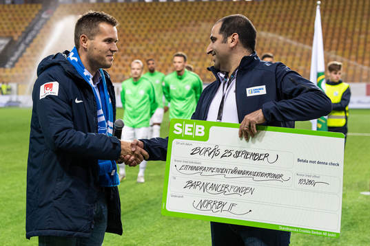 Norrbys klubbchef David Kryssman överlämnar en check till