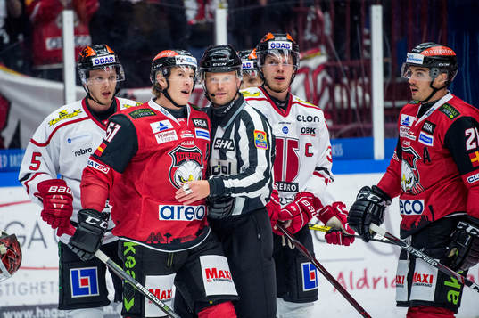 Domaren Ludvig Lundgren går emellan Malmö Redhawks Emil