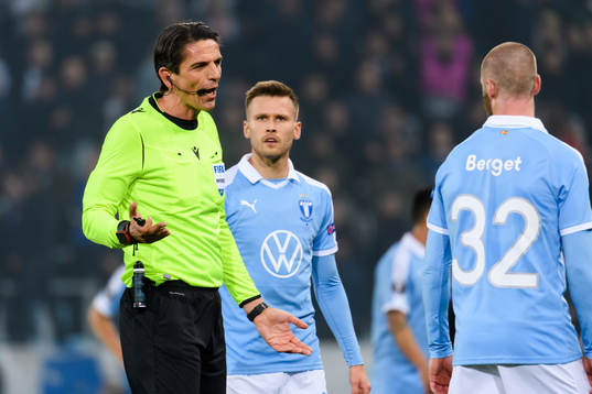 Referee Deniz Aytekin and Arnor Traustason of Malmö FF