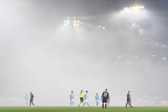 The pitch is covered in smoke