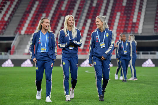 Sofia Jakobsson (centre) of Sweden inspects the pitch of