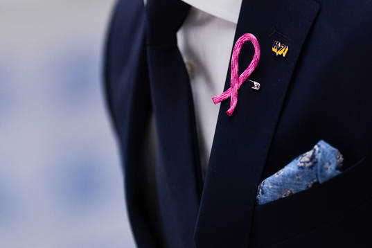 Rosa bandet på en kavaj och en HV71-pin