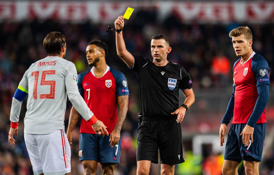 Sergio Ramos of Spain is shown a warning by referee Michael