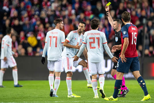 Sergio Busquets of Spain receives a yellow card from