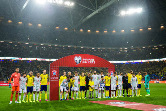 Players of Sweden and Spain hold up signs with the text