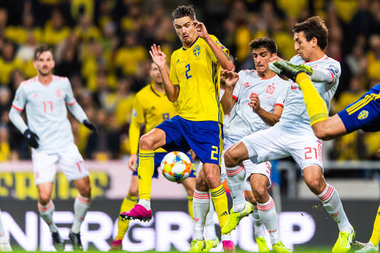Mikael Lustig of Sweden competes for the ball with Sergio