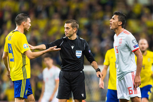 Marcus Berg of Sweden, referee Clement Turpin and Rodri of