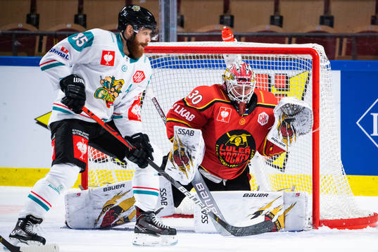 Liam Reddox of Belfast and goalkeeper David Rautio of Luleå