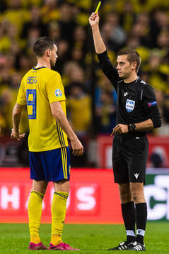 Marcus Berg of Sweden recieves a yellow card from referee