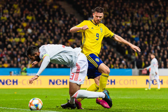 Raul Albiol of Spain and Marcus Berg of Sweden compete for