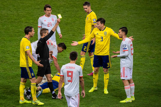 Dani Ceballos of Spain receives a yellow card from referee