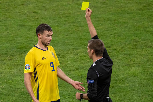 Marcus Berg of Sweden receives a yellow card from referee