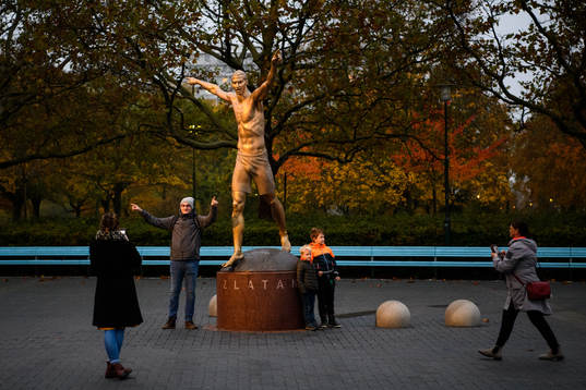 People take pictures with the statue of Zlatan Ibrahimovic