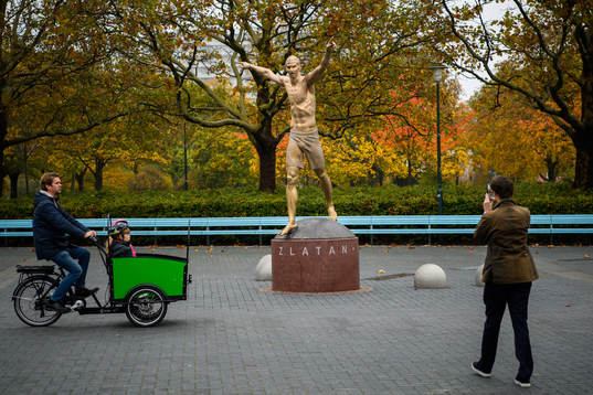 People take pictures with the statue of Zlatan Ibrahimovic