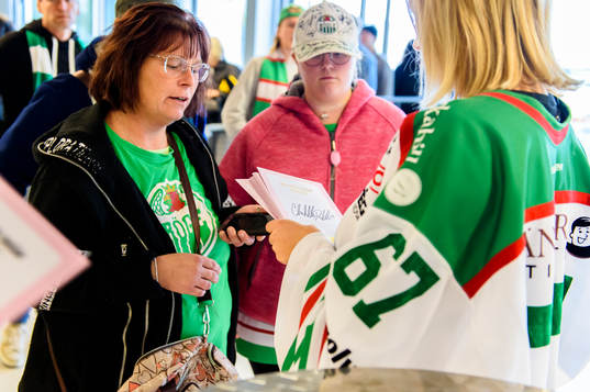 Försäljning av rosabandet lotter innan ishockeymatchen i