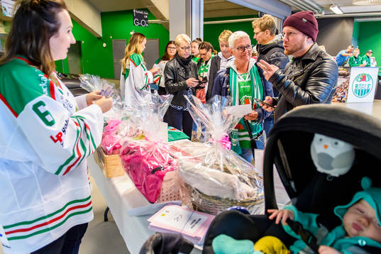 Försäljning av rosabandet lotter innan ishockeymatchen i