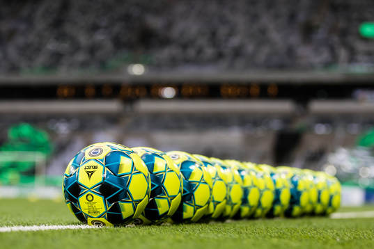 En rad med bollar ligger på planen innan fotbollsmatchen i