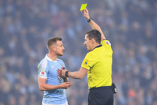 Malmö FFs Eric Larsson varnas av domare Bojan Pandzic
