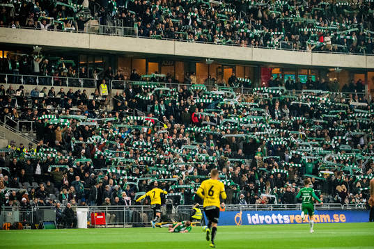 Spel pågår framför Hammarbys supportrar med halsdukar