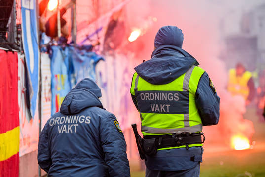Ordningsvakter övervakar Malmö FFs supportrar som