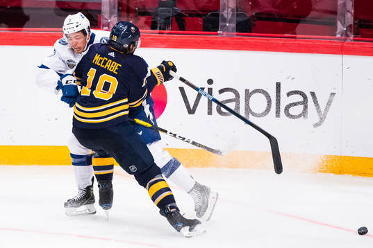 Jake McCabe of Buffalo Sabres tackles Mathieu Joseph of